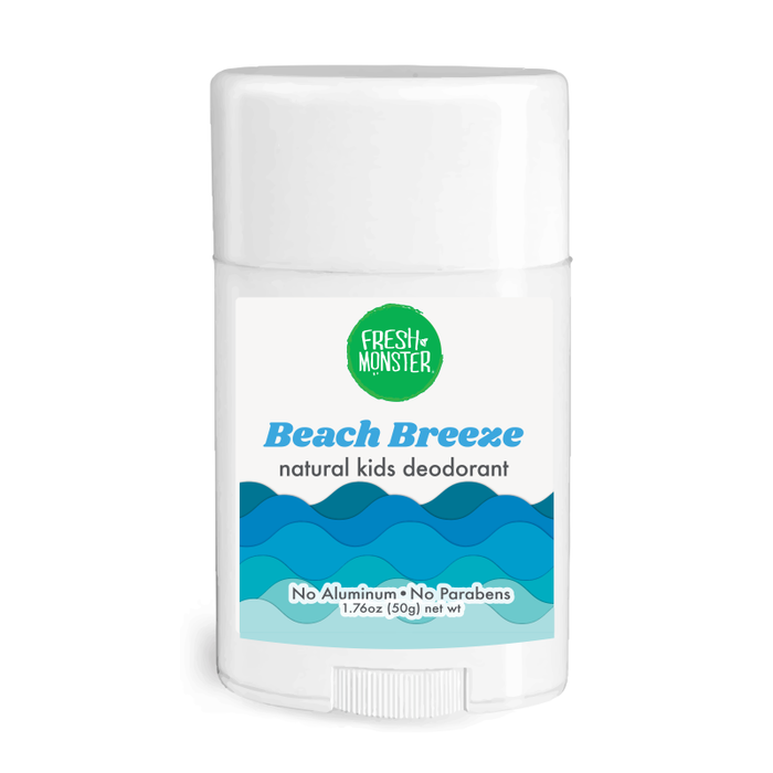 A white stick of Fresh Monster Beach Breeze natural kids deodorant with a blue wave design on the label. The label states No Aluminum • No Parabens and the net weight is 1.76oz (50g).