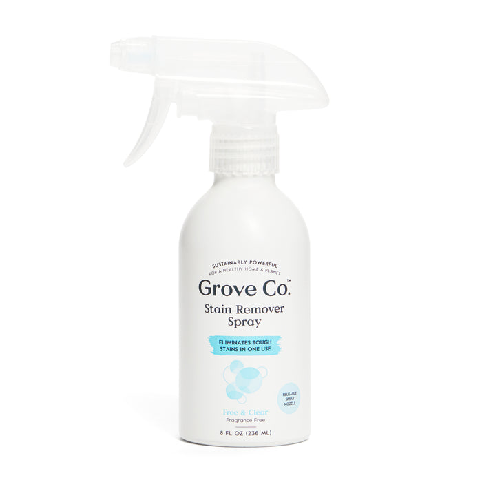 A white spray bottle labeled Grove Co. Stain Remover Spray with blue accents and the text Eliminates tough stains in one use. The bottle is 8 fl oz and marked Free & Clear, Fragrance Free.