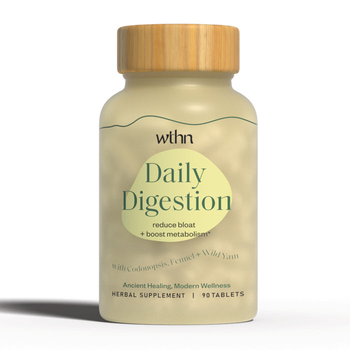 A beige bottle with a wooden cap labeled WTHN Daily Digestion herbal supplement, claiming to reduce bloat and boost metabolism, with 90 tablets. The label mentions codonopsis, fennel, and wild yam.