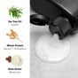 A bottle dispensing creamy lotion with text listing ingredients: Tea Tree Oil (Soothes), Wheat Protein (Repairs + Strengthens), and Shea Butter (Moisturizes). Includes illustrations of tea tree leaves, wheat, and shea butter.