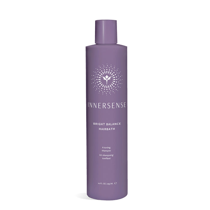 A tall, purple bottle of Innersense Bright Balance Hairbath shampoo with white text and a circular, radiant logo design on the front. The bottle size is 10 fl oz (295 mL).
