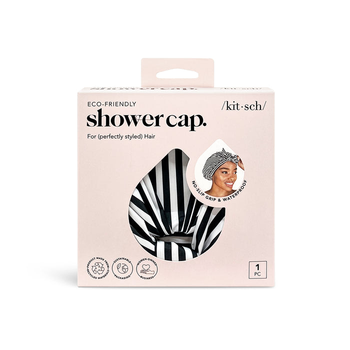 A box of eco-friendly Kitsch shower cap, black and white striped pattern visible through a teardrop-shaped window, with a photo of a woman wearing the cap and text stating no-slip grip & waterproof.