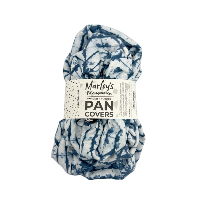 A rolled blue and white tie-dye reusable pan cover wrapped with a label reading Marleys Monsters PAN COVERS in black and grey text.