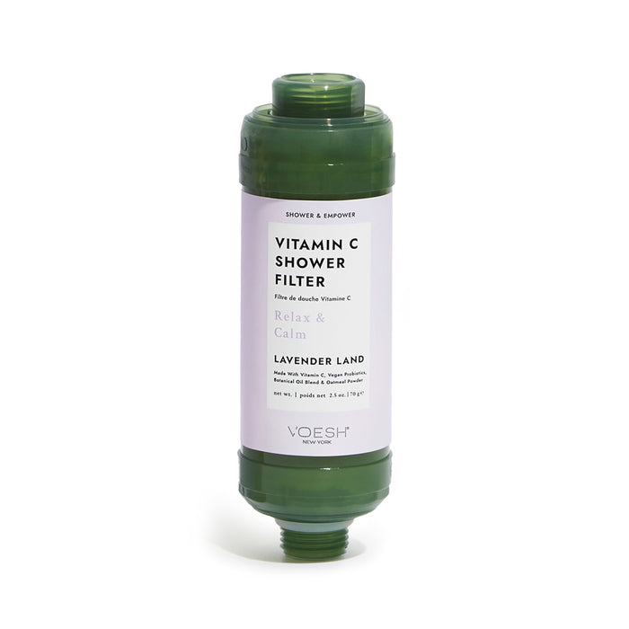 A green cylindrical Vitamin C shower filter labeled Lavender Land by VOESH New York, with a white label describing its relaxing and calming properties. The filter has threaded ends for attachment.