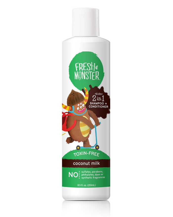 A white bottle of Fresh Monster kids 2-in-1 shampoo and conditioner, coconut milk scent, featuring a cartoon monster on a scooter. The label highlights “toxin-free” and “NO: sulfates, parabens, phthalates, dyes, or synthetic fragrances.”.