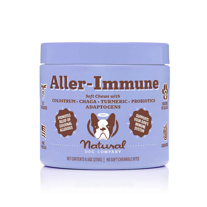 A lavender container of Natural Dog Company Aller-Immune soft chews featuring a dogs face logo and text highlighting ingredients like colostrum, chaga, turmeric, probiotics, and adaptogens for immune and allergy support.