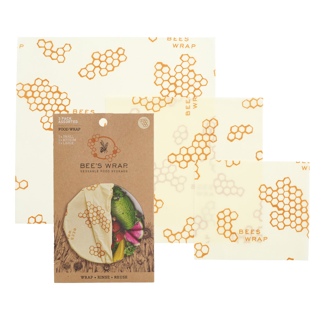 Bees Wrap Assorted Wraps features three sheets of reusable, eco-friendly food storage with a honeycomb pattern. The packaging includes a small round window displaying beeswax wrap covering fruit, serving as an alternative to plastic.
