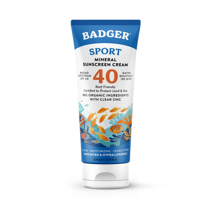 A tube of Badger Sport Mineral Sunscreen Cream SPF 40, featuring illustrations of orange fish swimming. The label highlights it as water resistant, reef friendly, made with organic ingredients, and unscented.