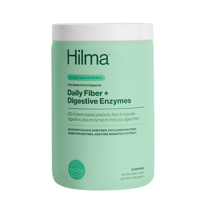 A green container of Hilma Daily Fiber + Digestive Enzymes supplement for sensitive stomachs, featuring plant-based fiber, prebiotics, and enzymes. The label highlights 30 servings and No sugar. Made with monkfruit.
