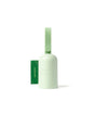 A light green Earth Rated dog waste bag dispenser with a textured strap and a partially pulled-out green waste bag labeled unscented on a white background.