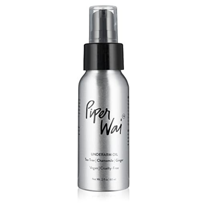 A silver bottle of PiperWai Underarm Oil with a black pump and cap, featuring text that highlights tea tree, chamomile, ginger, and labels such as vegan and cruelty-free.