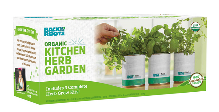 A box labeled Back to the Roots Organic Kitchen Herb Garden featuring three herb grow kits in white planters with green herbs. Text highlights organic certification and a 100% guarantee.