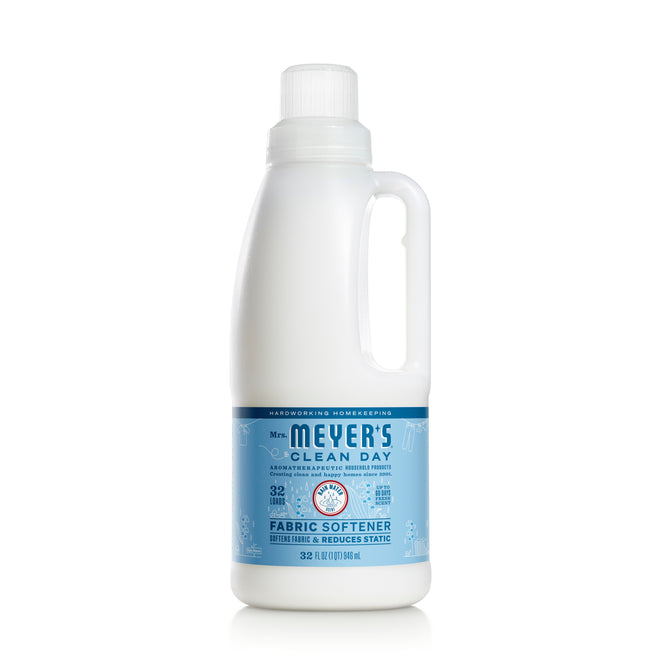 A 32 fl oz white plastic bottle of Mrs. Meyers Fabric Softener, infused with essential oils and featuring a blue label. Its biodegradable formula reduces static. The bottle has a handle and white cap, making it a laundry-room must-have.