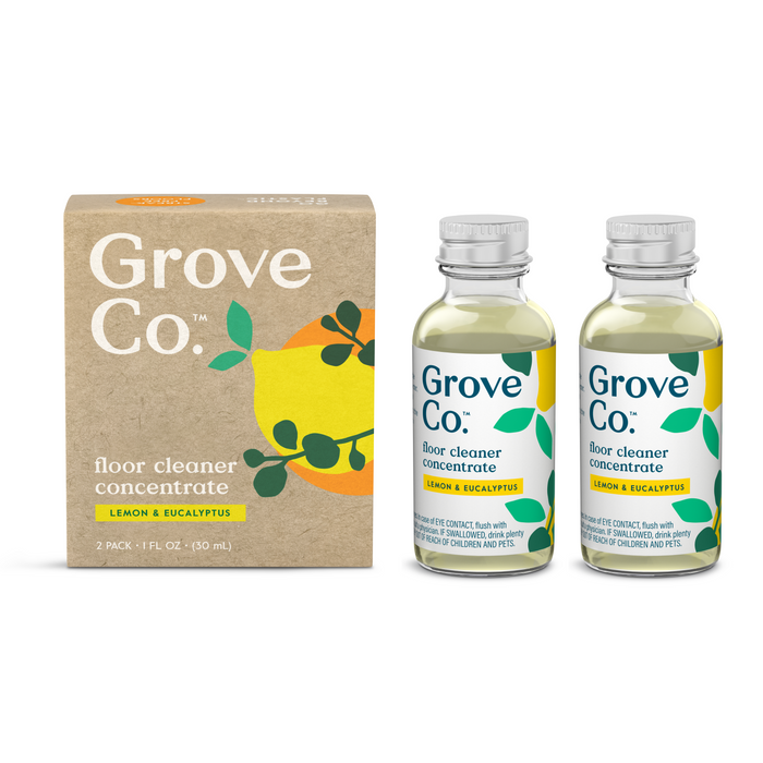 Grove Co. floor cleaner concentrate in lemon and eucalyptus scent, shown as a 2-pack with a brown box and two clear glass bottles with green caps and leafy label designs.