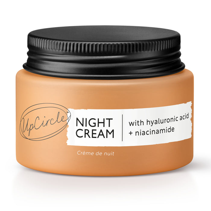 An orange jar of UpCircle Night Cream with a black lid. The label reads NIGHT CREAM with hyaluronic acid + niacinamide and Crème de nuit.